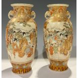 A pair of Japanese satsuma ovoid vases, decorated with courtyard and battle scenes, elephant mask