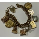 A 9ct gold curb link charm bracelet, suspended with two full gold sovereigns, Victorian 1895 and