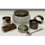 A George V silver mounted dressing table jar, Birmingham 1921; three silver napkin rings, 84g; a