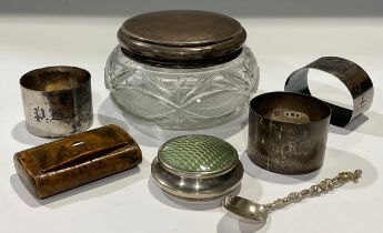 A George V silver mounted dressing table jar, Birmingham 1921; three silver napkin rings, 84g; a