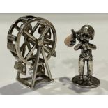 A miniature silver Ferris wheel, marked silver, 3.5cm high; a silver coloured metal figure, of a boy