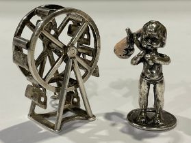 A miniature silver Ferris wheel, marked silver, 3.5cm high; a silver coloured metal figure, of a boy