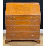 A George III oak bureau, fall front enclosing small drawers and pigeonholes, above four long