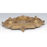 A Victorian brass inkstand, in the Renaissance Revival taste, central arched handle terminating in