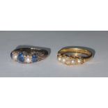 A gold coloured metal, sapphire and seed pearl ring, the three stones separated by two seed