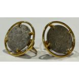 A pair of gold coloured metal earrings, set with a coin