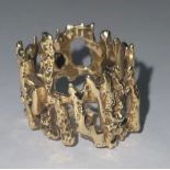 A gold coloured metal open work bark effect ring, approximately 7g, size I/J