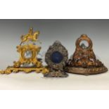 A 19th century cast iron bow front pocket watch stand, cast with a pair of sea serpents and