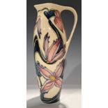 A contemporary Moorcroft single handled jug, signed by Philip Gibson, tube lined with pink and lilac