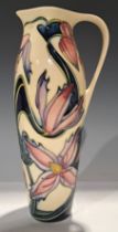 A contemporary Moorcroft single handled jug, signed by Philip Gibson, tube lined with pink and lilac