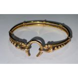 A gold coloured metal hollow cast bangle, the clasp as a horse shoe, approximately 7g