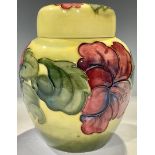 A Moorcroft Hibiscus pattern ginger jar and coverl, tube lined with flowers on a yellow ground, 15.