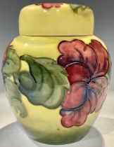 A Moorcroft Hibiscus pattern ginger jar and coverl, tube lined with flowers on a yellow ground, 15.