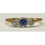 An 18ct gold three stone sapphire and diamond ring, platinum milled bezel, size R, 2.5g