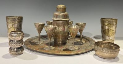 An Indian plated eight piece cocktail set, comprising three piece cocktail shaker, six conical