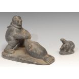 An Inuit soapstone carving, of a hunter and a seal, 21cm long, label for Canadian Inuit Art, mid