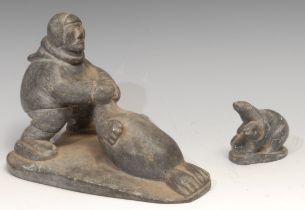 An Inuit soapstone carving, of a hunter and a seal, 21cm long, label for Canadian Inuit Art, mid