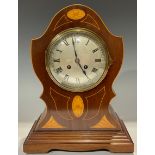 An Edwardian mahogany cartouche shaped mantel clock, silvered circular dial, Roman numerals, twin