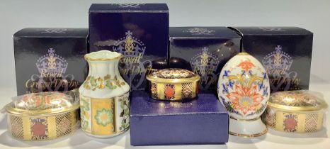 A set of three Royal Crown Derby 1128 pattern graduated oval trinket pots and covers, each boxed;