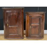 A George III oak corner cabinet, 94cm high; another, slightly later and smaller, 80.5cm high (2)