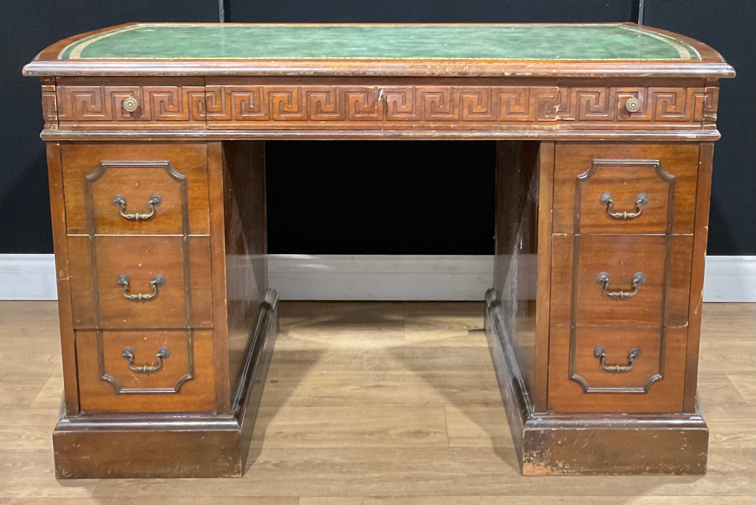 A George III Revival mahogany desk, discorectangular top with inset tooled and gilt writing