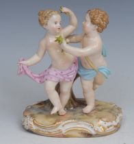 A German porcelain figure group, putti suitors gathering blooms, 12cm high, impressed 2996,