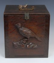 A late 19th century oak pigeon carrying box, brass handle, the fall front carved and applied with