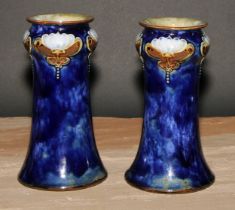 A pair of Art Nouveau Royal Doulton stoneware vases, by Maud Bowden, moulded with stylised
