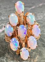 A 14ct gold and opal modernist bark effect ring, each opal cabochon claw set