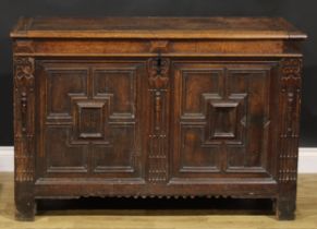 A 17th century oak blanket chest, hinged top, the two-panel front applied with geometric