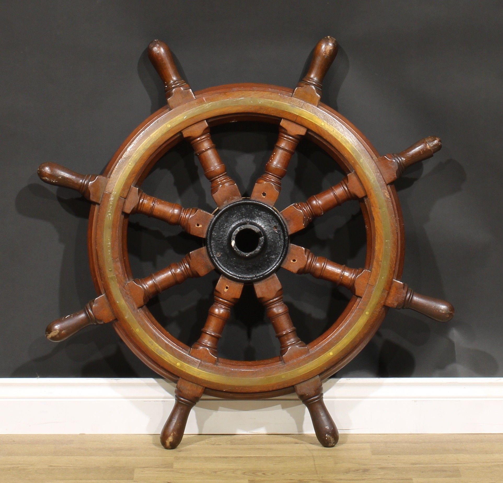 An early 20th century brass bound oak ship’s wheel, iron hub, turned spokes, 93cm diameter