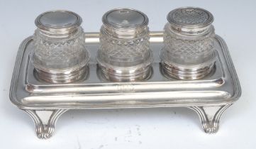 A George IV silver three-bottle inkstand, reeded borders, outswept scroll feet, 22.5cm wide,