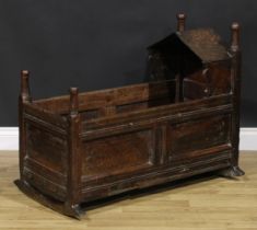 A '17th century' oak wainscote rocking crib, turned finials, pointed arched canopy, 76cm long,