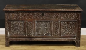 A late 17th century oak blanket chest, hinged top with wavy lappet border, three panel front