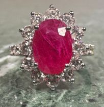 A certified ruby and diamond ring, central purplish red mixed cut oval ruby, 3.08ct, surrounded by a