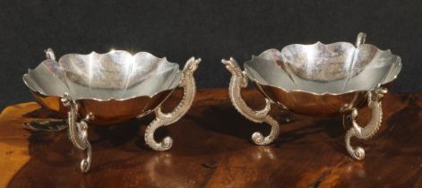 A pair of Chinese silver lotus shaped dishes, each with three dragon shaped supports, 9.5cm diam,