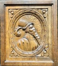 A North European oak Romayne panel, carved in relief with an oval profile portrait of a gentleman in