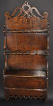 A George III Welsh oak spoon rack, shaped and pierced pediment above twelve provisions and a