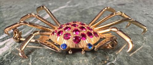 A gold coloured metal crab brooch, the carapace set with 21 circular red facet cut stones, the