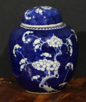 A Chinese ovoid ginger jar and cover, painted in tones of underglaze blue with blossoming prunus