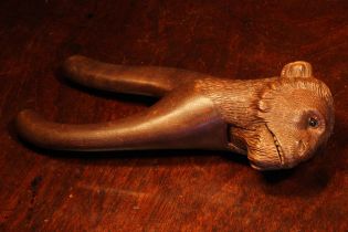Nutcrackers - a Black Forest novelty lever action nut cracker, carved as the head of a monkey, glass