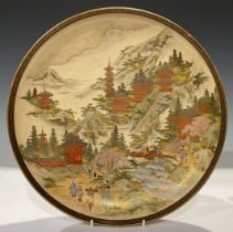 A Japanese satsuma charger, painted in the typical palette and picked out in gilt with figures in