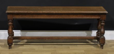 A 17th century style oak window seat or bench, rectangular top with moulded edge, turned and blocked