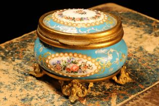 A 19th century French gilt metal mounted enamel oval jewel casket, painted with flowers within '