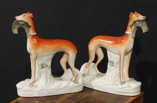 A pair of 19th century Staffordshire hunting dogs, each retrieving hare, 28cm high