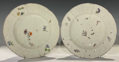 A pair of Chelsea shaped circular plates, moulded with flowers and painted in polychrome with