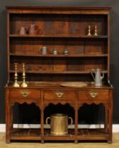 A George III oak pot-board dresser, possibly Shropshire, outswept cornice above three shelves, the