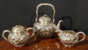 A Japanese silver three piece tea service, comprising kettle-form teapot, milk jug and sucrier, each