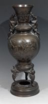 A Japanese dark patinated bronze gourd shaped vase, pair of dragon handles, tripod base, the