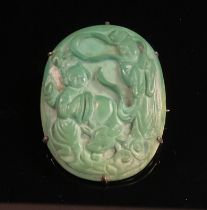 A late Qing dynasty green peking glass oval brooch, carved with figures in traditional dress above a